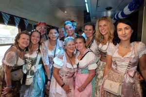 Partyzug mit jungen Menschen die im Abteil feiern und fröhlich sind